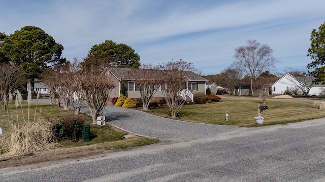 ranch-style house with gravel driveway and a front lawn