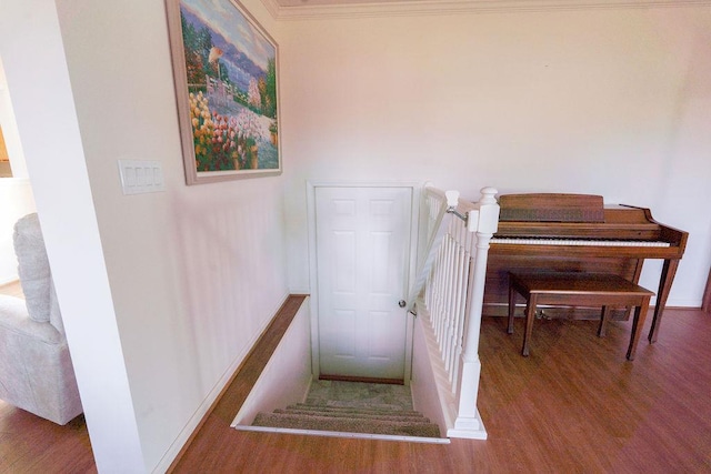 stairway with crown molding, baseboards, and wood finished floors