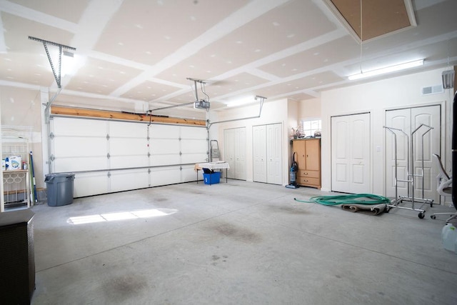 garage featuring a garage door opener and visible vents