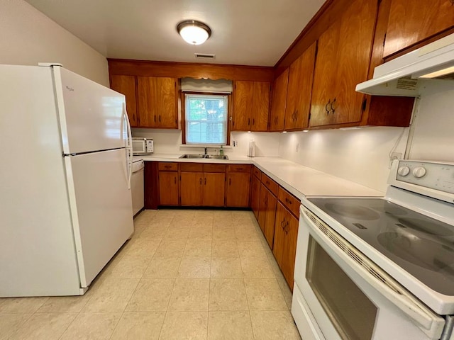 2048 Lake Rd, Lottsburg, VA 22511 - kitchen featuring white appliances, brown cabinets, light countertops, under cabinet range hood, and a sink