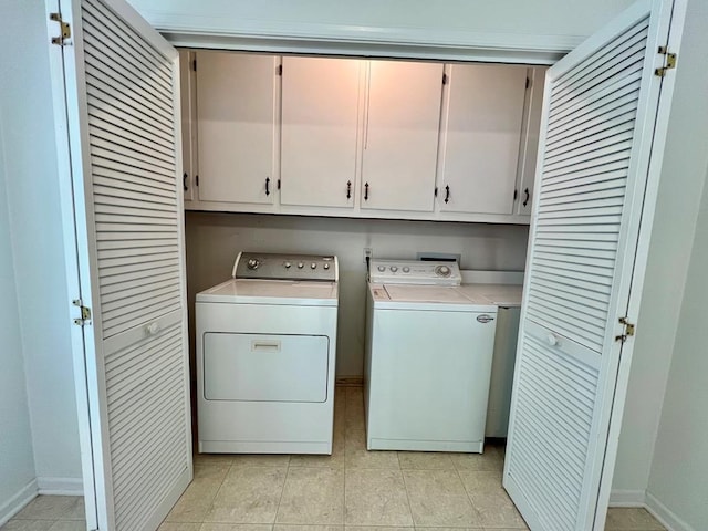2048 Lake Rd, Lottsburg, VA 22511 - washroom featuring cabinet space, separate washer and dryer, light tile patterned floors, and baseboards