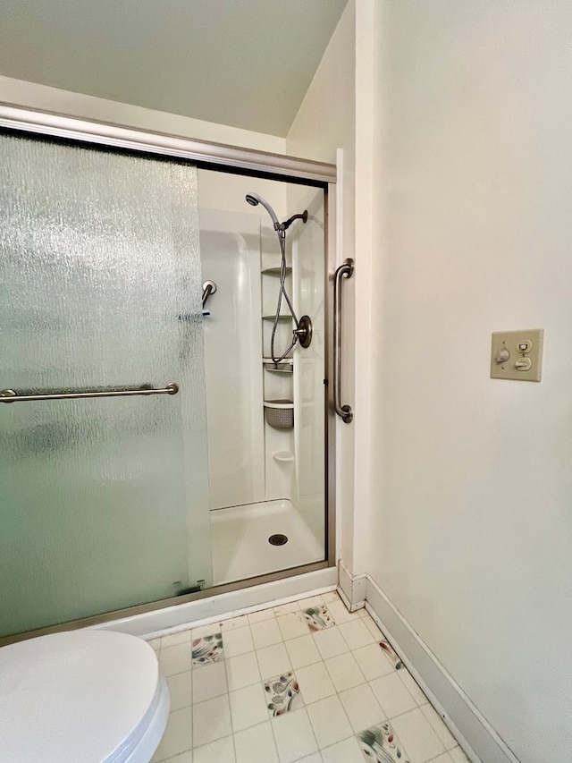 bathroom featuring toilet and a shower with door