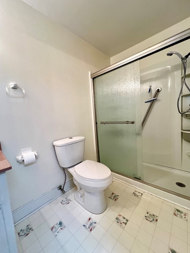 bathroom with a shower with door and toilet