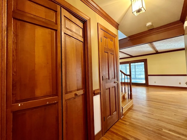 hallway with ornamental molding and light wood-type flooring