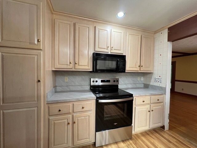 1113 Dillard St, Tappahannock, VA 22520 - kitchen featuring stainless steel electric range, black microwave, light countertops, light wood-style floors, and backsplash