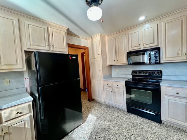 kitchen with hanging light fixtures, cream cabinetry, and black appliances