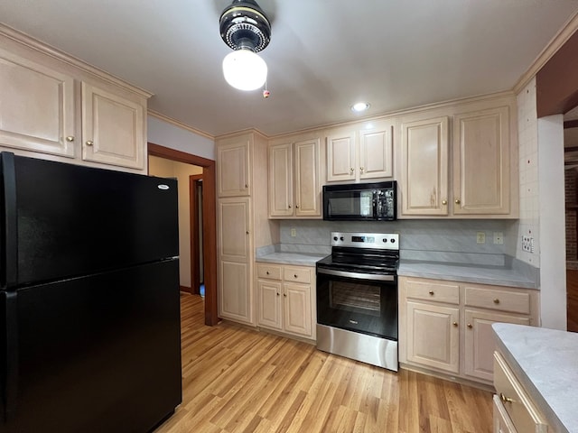 1113 Dillard St, Tappahannock, VA 22520 - kitchen with black appliances, light countertops, light wood-style floors, decorative backsplash, and ornamental molding