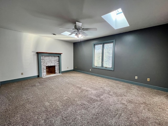 unfurnished living room with a brick fireplace, carpet, and ceiling fan