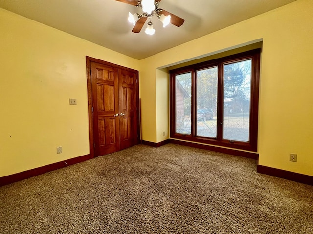 unfurnished bedroom with carpet floors, ceiling fan, and a closet