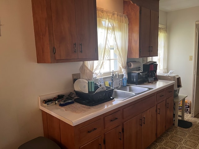 155 Rouzie Dr, Tappahannock, VA 22560 - kitchen featuring a sink, light countertops, and brown cabinetry