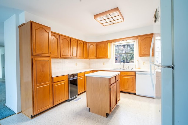 kitchen with decorative backsplash, a center island, white appliances, and sink