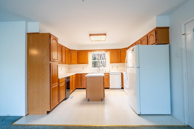 kitchen featuring backsplash, sink, a kitchen island, and white appliances