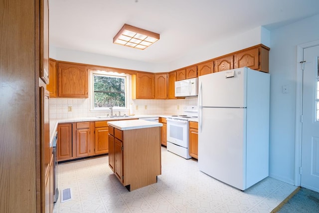 kitchen with white appliances, tasteful backsplash, a kitchen island, and sink