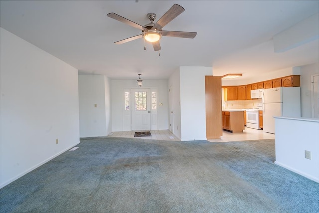 unfurnished living room featuring light carpet and ceiling fan