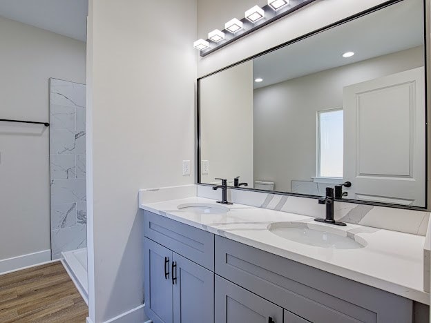 bathroom with hardwood / wood-style flooring, vanity, toilet, and walk in shower