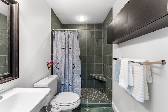 326 Chase St, Kilmarnock, VA 22482 - bathroom featuring toilet, a tile shower, a sink, tile patterned flooring, and a textured ceiling