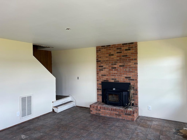 unfurnished living room with a wood stove