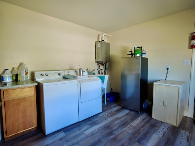 laundry area with separate washer and dryer, tankless water heater, dark hardwood / wood-style flooring, and cabinets