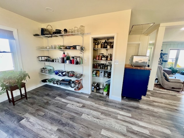 interior space with attic access, baseboards, and wood finished floors