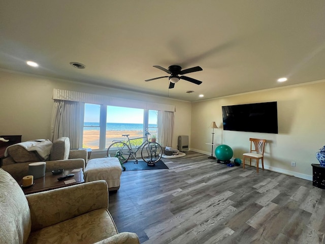 living area with crown molding, baseboards, and wood finished floors