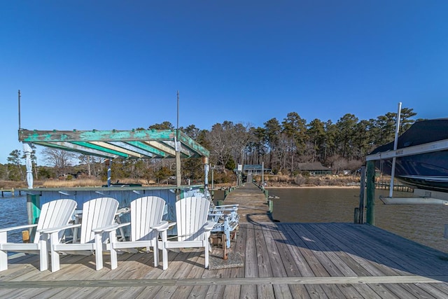 wooden terrace featuring a boat dock and a water view