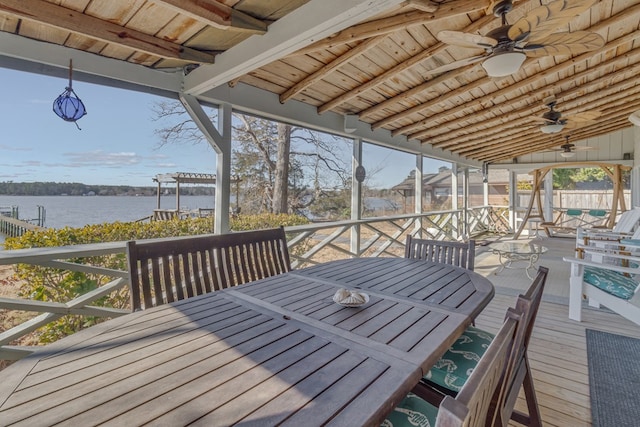 deck with a water view, ceiling fan, and outdoor dining space