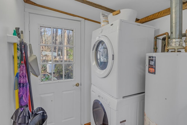 laundry room featuring laundry area, stacked washer and clothes dryer, and gas water heater