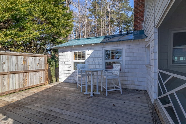 wooden deck with an outdoor structure and fence