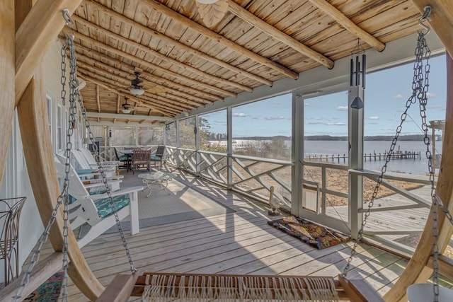 wooden terrace featuring outdoor dining space and a water view