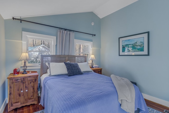 bedroom with lofted ceiling, baseboards, and wood finished floors