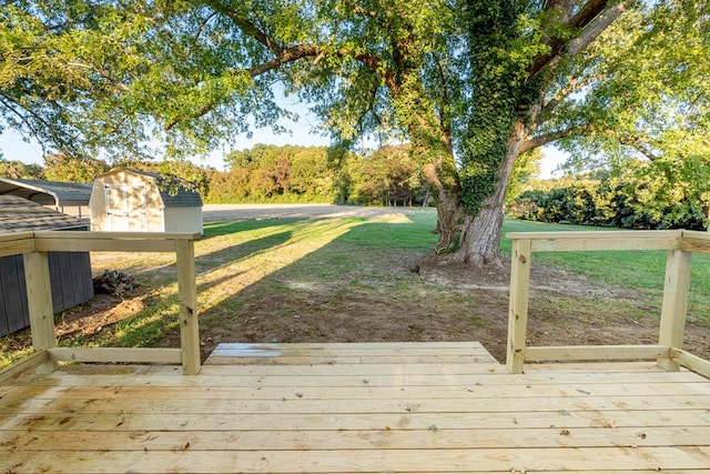 wooden terrace featuring a storage shed and a lawn