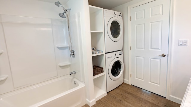 laundry area with hardwood / wood-style flooring and stacked washer / drying machine