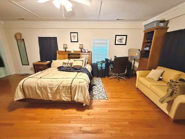 bedroom with ornamental molding, ceiling fan, and light hardwood / wood-style flooring