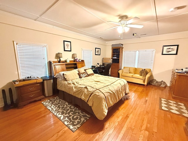 bedroom with light hardwood / wood-style flooring, ornamental molding, and ceiling fan