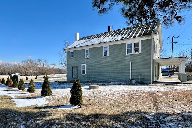 snow covered back of property featuring central AC unit