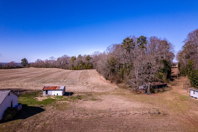 view of yard with a rural view and an outdoor structure