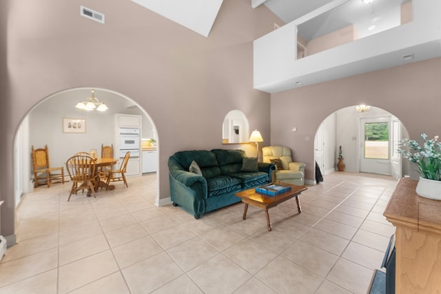 367 Edgewater Ln, Montross, VA 22520 - living room featuring arched walkways, high vaulted ceiling, light tile patterned floors, a chandelier, and baseboards