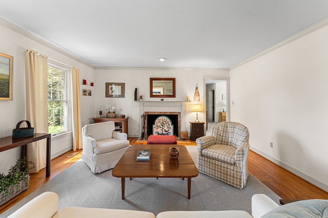 living area featuring ornamental molding, wood finished floors, and a fireplace