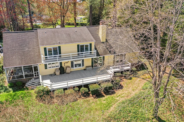 rear view of house with a deck, a chimney, a balcony, and roof with shingles