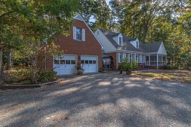 cape cod house with a garage and a sunroom