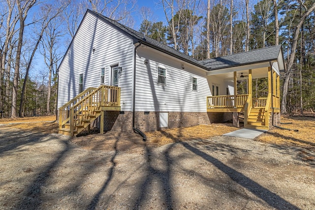 view of side of property featuring crawl space, a shingled roof, and ceiling fan