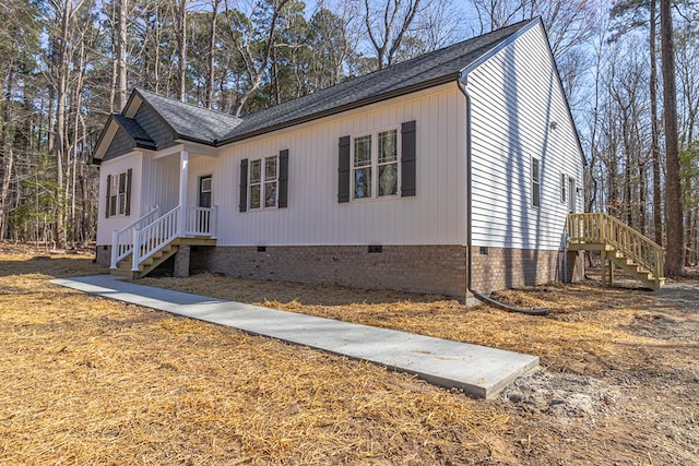 view of front facade with roof with shingles and crawl space