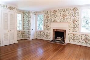 567 Seaford Ln, Mathews, VA 23109 - unfurnished living room featuring hardwood / wood-style flooring and a brick fireplace