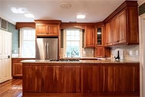 567 Seaford Ln, Mathews, VA 23109 - kitchen with gas cooktop, hardwood / wood-style floors, backsplash, and stainless steel refrigerator