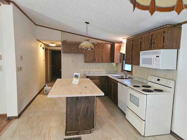 kitchen with pendant lighting, lofted ceiling, a center island, and white appliances