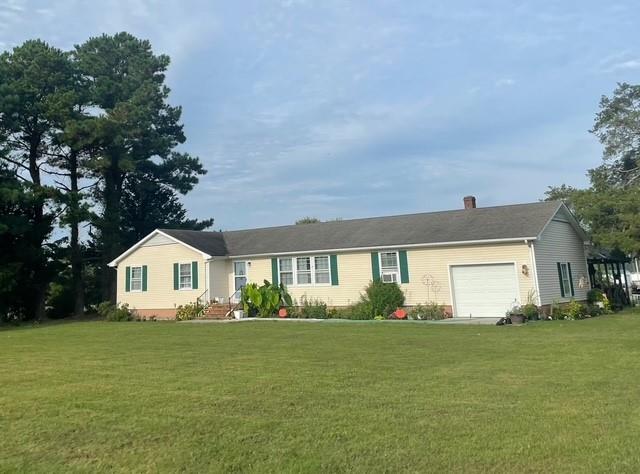 single story home with a garage and a front lawn