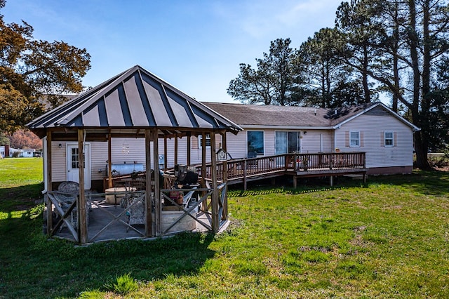 back of house featuring a gazebo, a wooden deck, a yard, and a patio area