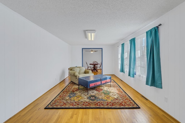 living area with hardwood / wood-style flooring and a textured ceiling