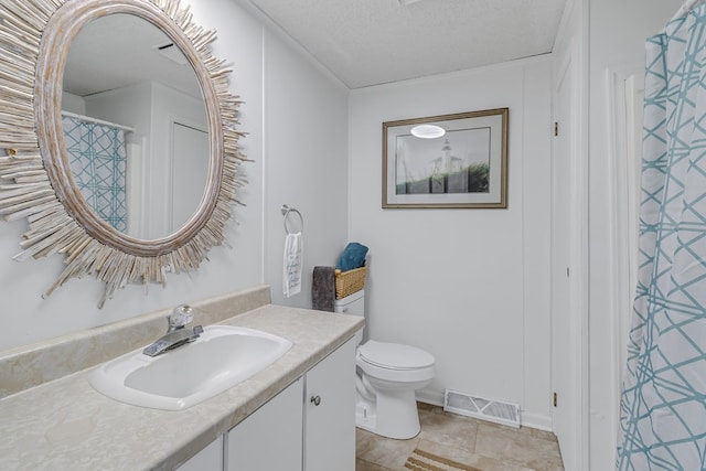 bathroom with vanity, tile patterned flooring, toilet, and a textured ceiling