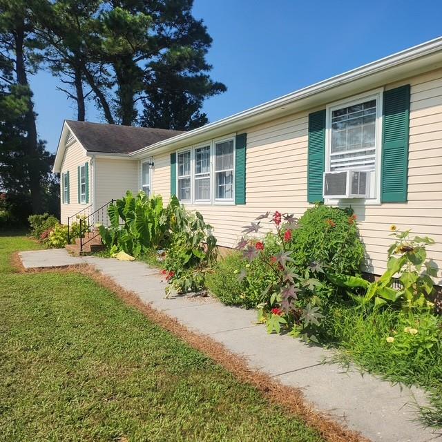 view of property exterior featuring cooling unit and a lawn